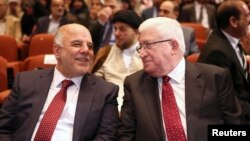 El nuevo primer ministro iraquí, Haider al-Abadi (izquierda) y el presidente de ese país, Fouad Massoum, conversan durante la sesión en que se aprobó el nuevo gobierno.