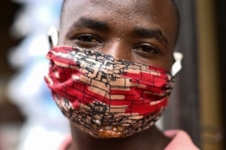 Pierre Mahiraguha, a vendor at the Kimironko market wears a handmade "kitenge" cloth mask as he attempts to protect himself against the coronavirus disease (COVID-19), in Kigali, Rwanda, March 17, 2020.