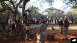 Un chasseur américain Steve Schultz, à gauche, essaie son arc de chasse avant de quitter le camp de Melorani Safaris au Olifantsvallei, en Afrique du Sud, 18 avril 2015