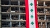 A banner with representations of the Lebanese flag hangs on a damaged building in a neighborhood near the site of last week's explosion that hit the seaport of Beirut, Lebanon, Aug. 12, 2020. 