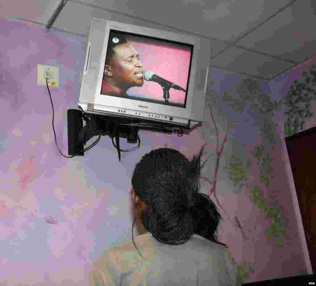 In a pediatric ward, a 16-year-old with HIV and multi-drug resistant tuberculosis who battles to talk and to breathe watches television. She plans to become a doctor who will help others.&nbsp;(Photo by Darren Taylor) &nbsp; &nbsp; &nbsp;