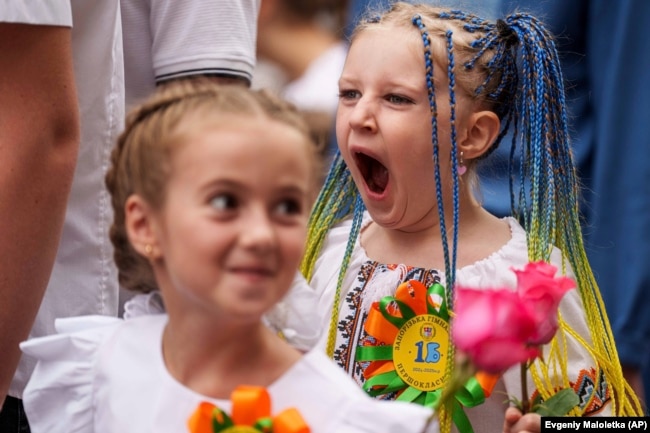 Children attend the traditional ceremony for the first day of school in Zaporizhzhia, Ukraine, Sunday Sept. 1, 2024. (AP Photo/Evgeniy Maloletka)