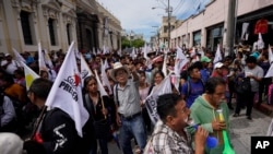 Participantes en una protesta organizada por el Comité de Desarrollo Campesino (CODECA) para pedir la renuncia de la fiscal general, detener los desalojos, y el fin de lo que llaman privilegios para las grandes corporaciones en Ciudad de Guatemala, el 10 de julio de 2024.