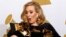 FILE - Singer Adele holds her six Grammy Awards at the 54th annual Grammy Awards in Los Angeles, California February 12, 2012. 