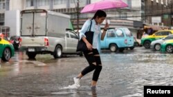 A woman walks on a flooded street in Bangkok, Thailand, Sept. 24, 2018.