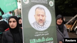 Žene nose plakat sa slikom zamjenika čelnika Hamasa, Saleha al-Arourija, ubijenog, kako libanonski i palestinski sigurnosni izvori kažu, napadom izraelske bespilotne letjelice.