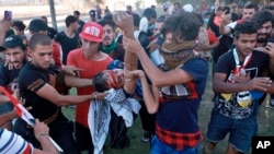 An injured protester is rushed to the hospital after being shot during a demonstration in Baghdad, Iraq, Oct. 4, 2019.