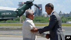 Presiden AS Barack Obama berjabat tangan dengan Menteri Pertahanan Nasional Filipina Voltaire Gazmin saat tiba di Bandar Udara Internasional Ninoy Aquino di Manila (17/11). (AP/Susan Walsh)