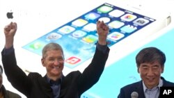 Tim Cook, director ejecutivo de Apple, y el presidente de China Mobile, participan en un evento promocional de iPhone en Beijing, el 17 de enero.