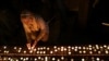 A woman lights a candle during a commemoration of the first anniversary of the October 7 Hamas attacks on Israel at the the Dohany Street Synagogue in Budapest