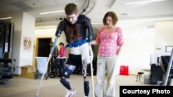 Former Marine Sgt. John Peck is seen walking on artificial limbs before having a double arm transplant. (Photo: Courtesy John Peck)