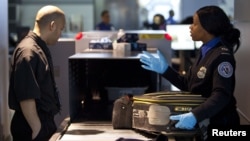 In this 2012 file photo, a Transportation Security Administration (TSA) security agent checks a traveler's luggage at John F. Kennedy Airport in New York. (REUTERS/Andrew Burton)