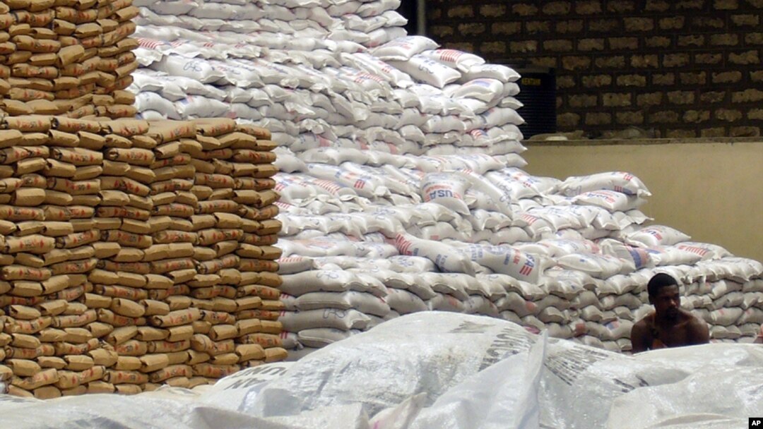 FILE - A worker takes a lunch break while sitting amongst the stack of food aid, at the U.N. World Food Program warehouse in Mombasa, Kenya, Dec. 3, 2008. 