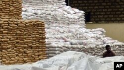 FILE - A worker takes a lunch break while sitting amongst the stack of food aid, at the U.N. World Food Program warehouse in Mombasa, Kenya, Dec. 3, 2008. 