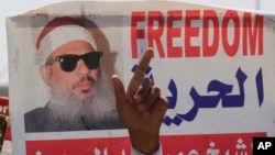 Le doigt d'un manifestant pointé en l'air devant l’effigie de Sheik Omar Abdel-Rahman, religieux égyptien aveugle emprisonné aux Etats-Unis pour avoir planifié une campagne d'attentats à la bombe, le 11 septembre 2011.