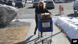 Chugiak-Eagle River Food Pantry volunteer Joy Thompson wheels donations from area grocery stores into the pantry inside a Presbyterian church in Eagle River, Alaska on April 21, 2023.