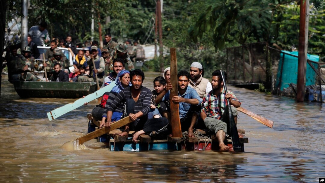 Warga Kashmir menggunakan rakit untuk menyelamatkan warga yang terkena musibah banjir di Srinagar, wilayah Kashmir yang dikuasai India (10/9). Pihak berwenang mengatakan banjir yang melanda India dan Pakistan ini telah menewaskan lebih dari 440 jiwa.