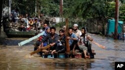 Warga Kashmir menggunakan rakit untuk menyelamatkan warga yang terkena musibah banjir di Srinagar, wilayah Kashmir yang dikuasai India (10/9). Pihak berwenang mengatakan banjir yang melanda India dan Pakistan ini telah menewaskan lebih dari 440 jiwa.