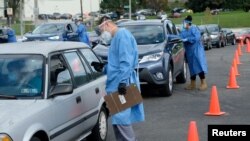 FILE - People line up in their vehicles to undergo the coronavirus disease (COVID-19) tests, distributed by the Wisconsin National Guard at the United Migrant Opportunity Services center, in Milwaukee, Wisconsin, Oct. 2, 2020.