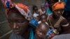 Des femmes déplacées avec leurs enfants attendent de l'aide dans un bâtiment utilisé par des réfugiés comme abri à Pemba, au Mozambique, après avoir fui les attaques à Palma dans le nord du Mozambique, le 19 avril 2021. 