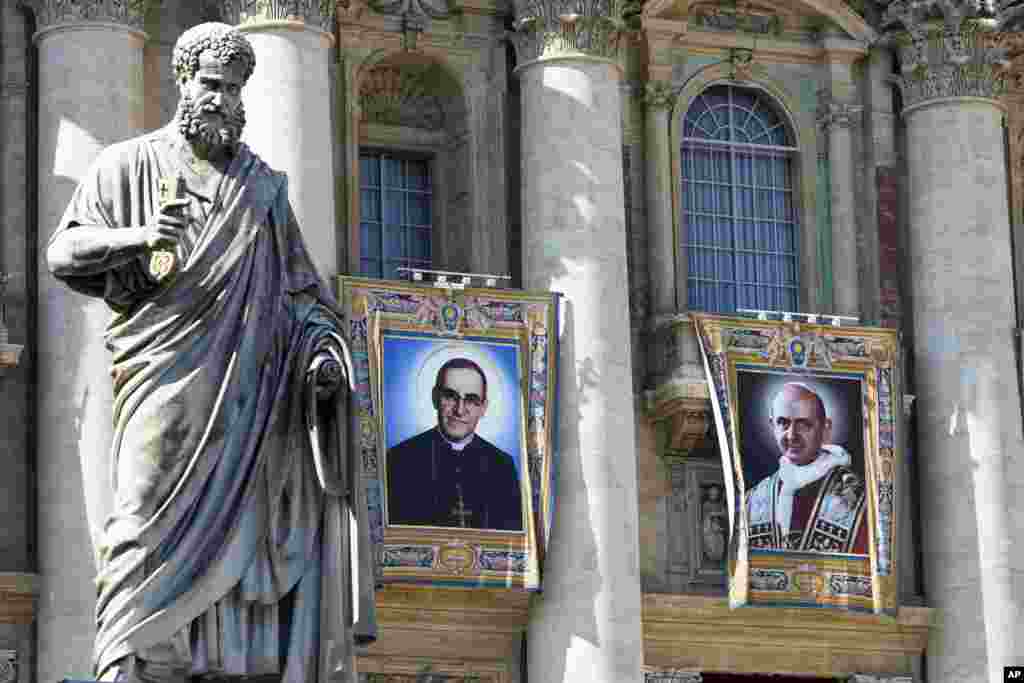 Tapices del arzobispo católico Oscar Romero, a la izquierda, y el papa Pablo VI cuelgan de un balcón de la fachada de la Basílica de San Pedro en el Vaticano, el sábado 13 de octubre de 2018. El papa Francisco canonizó a ambos al día siguiente, el domingo 14 de octubre. Romero y Paulo VI son dos de las más importantes y disputadas figuras de la Iglesia católica del siglo XX. (Foto AP / Andrew Medichini)