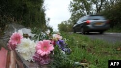 Floral tributes lay on the roadside near RAF Croughton in Northamptonshire, central England on Oct. 10, 2019, at the spot where British motorcyclist Harry Dunn was killed.