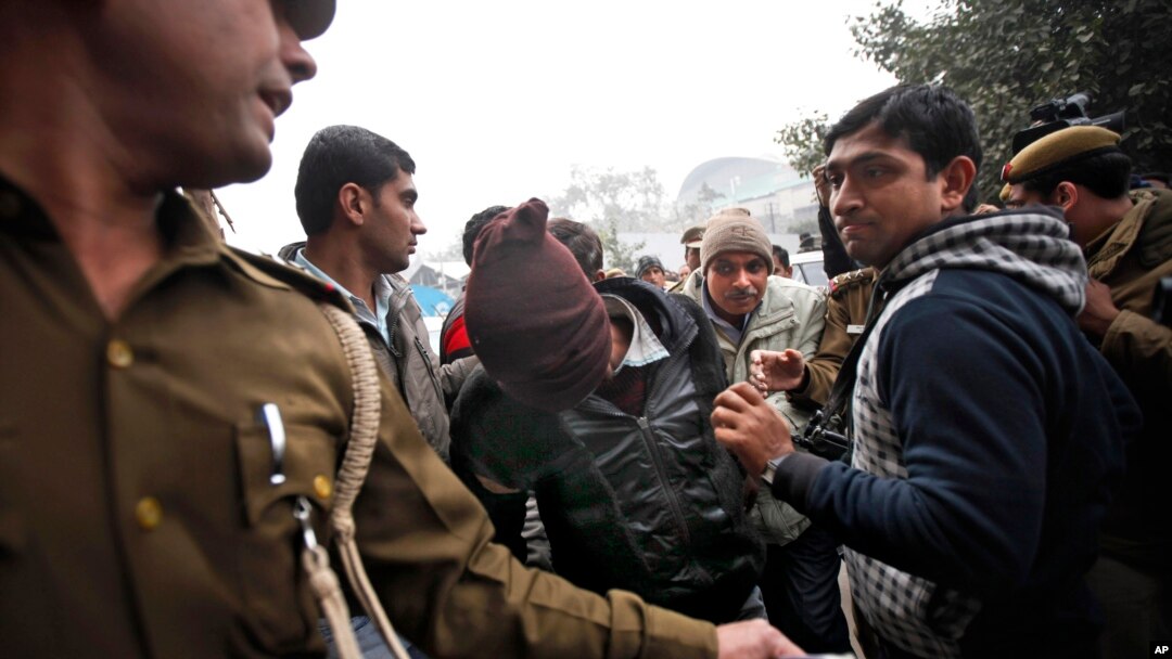 Police officials escort an accused in the gang rape of a 51-year-old Danish tourist to produce him in court in New Delhi, India, Jan. 16, 2014.