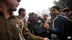 Police officials escort an accused in the gang rape of a 51-year-old Danish tourist to produce him in court in New Delhi, India, Jan. 16, 2014.