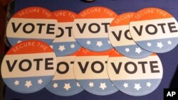 Computer mouse pads with Secure the Vote logo are seen on a vendor's table at a convention of state secretaries of state, July 14, 2018, in Philadelphia.