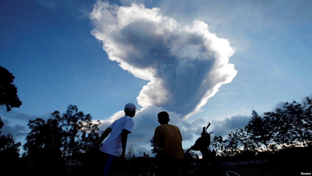 Personas miran como el volcán Monte Merapi entra en erupción desde Purwobinangun Village, cerca de Yogyakarta, Indonesia.