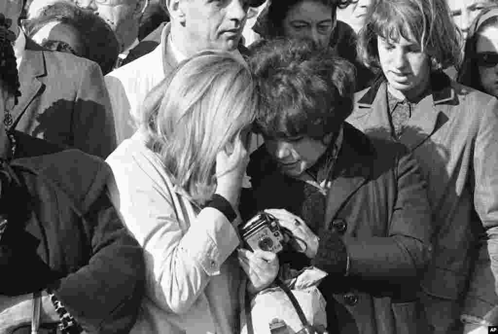 Warga yang menangis di tengah kerumunan yang menunggu iring-iringan pembawa jenazah Presiden John F. Kennedy lewat di Washington, DC, 24 November 1963.