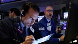 Para pialang di New York Stock Exchange hari Kamis (12/3). Indeks bursa New York kembali anjlok lebih dari 2.000 point dan tercatat pada 21.450 menjelang tutup pasar.