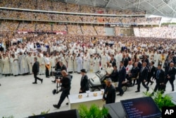 Umat menanti di Stadion Nasional Singapore SportsHub tempat Paus memimpin misa di Singapura, Kamis, 12 September 2024. (Foto: AP)