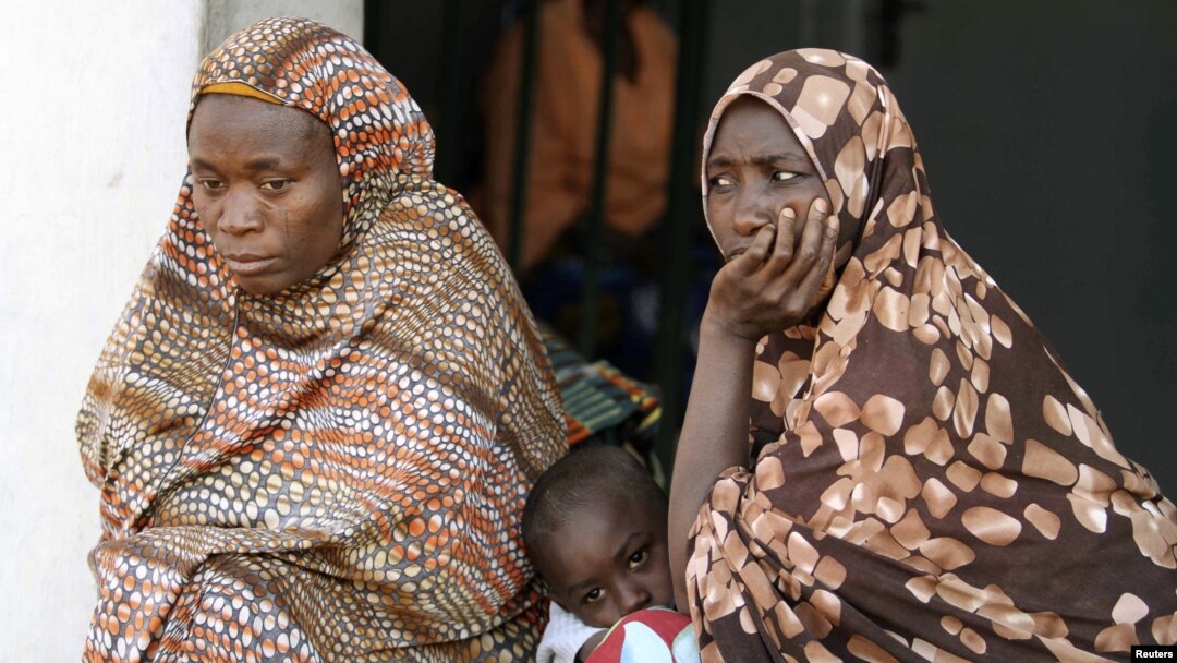 Women sit with their children at a camp for internally displaced people in Nigeria's central city of Jos. 