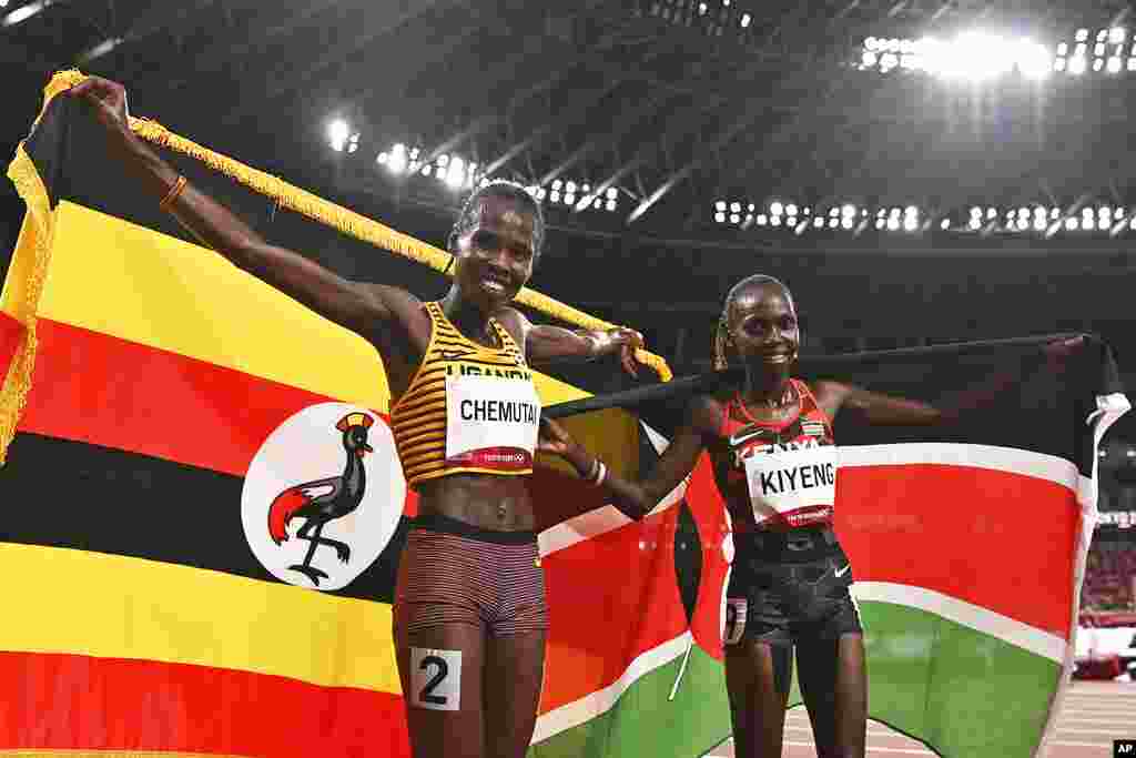 Uganda's Peruth Chemutai, left, and Kenya's Hyvin Kiyeng celebrate after Chemutai won gold and Kiyeng won silver in the women's 3,000-meter steeplechase final at the 2020 Summer Olympics in Tokyo, Japan, Wednesday, Aug. 4, 2021. (Ben Stansall/Pool Photo via AP)
