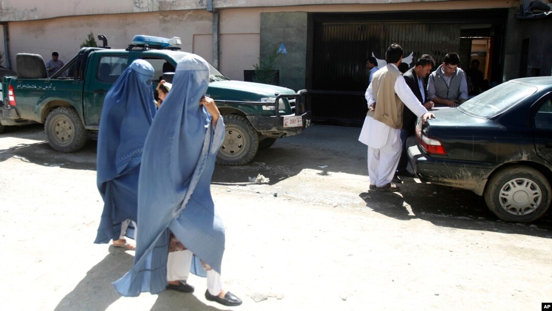 Những phụ nữ Afghanistan đi qua nhà khách Park Palace ngày 15/5/2015 ở Kabul sau khi nhà khách này bị tấn công bởi các tay súng.