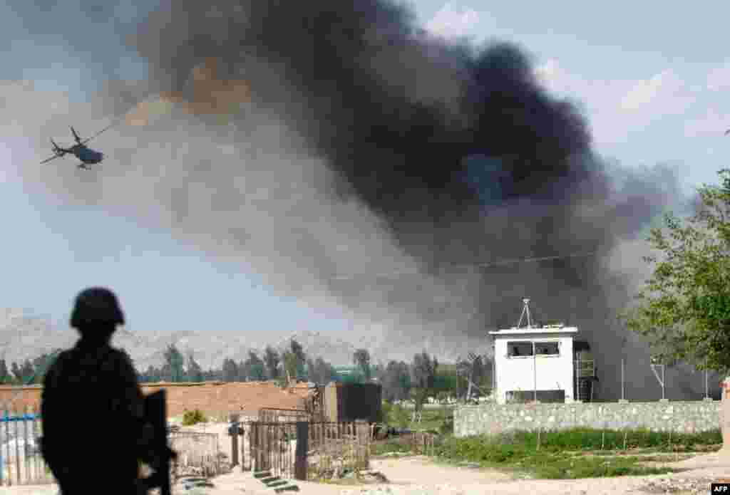 An Afghan National Army soldier near the Provincial Reconstruction Team (PRT) as a NATO helicopter flies over the site of an attack in Jalalabad province April 15, 2012 (Reuters/Parwiz)