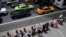 FILE - A ride-hailing car, a yellow cab and a green cab make their way across 42nd Street as passengers wait in line at a taxi stand outside Grand Central Terminal in New York, Aug. 1, 2018.