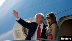 Presiden AS, Donald Trump, dan ibu negara Melania Trump melambaikan tangan sebelum masuk ke dalan Air Force One untuk bertolak kembali ke Washington, dari Bandara Internasional Hamburg, Jerman, 8 Juli 2017 (foto: REUTERS/Carlos Barria)