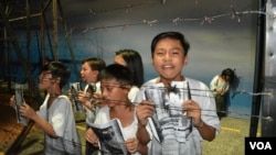 A dramatization of children in the "Hall of Orphans" begging for any information about parents, siblings and other relatives who went missing during the martial law years of the Philippines . EDSA Revolution Experiential Museum, Quezon City, Feb. 24, 2016. (S. Orendain/VOA)