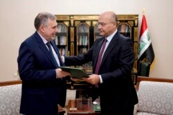 Iraqi President Barham Salih, right, instructs newly appointed Prime Minister Mohammed Allawi in Baghdad, Feb. 1, 2020.