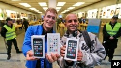 First customers of the Apple store in Oberhausen< Germany, are all smiles with their new iPhones on Sept. 20, 2013.