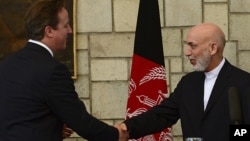 Afghan President Hamid Karzai, right, shakes hands with British Prime Minister David Cameron during a press conference at the presidential palace in Kabul, Afghanistan, June 29, 2013.