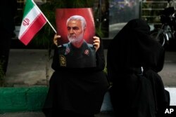 FILE —A demonstrator holds a poster of the late Iranian Revolutionary Guard Gen. Qassem Soleimani, who was killed in a U.S. drone attack in 2020, at a rally in Tehran, Iran, on November 4, 2023.