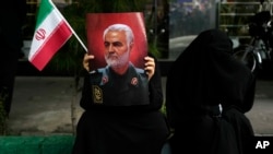 Manifestante sostiene un cartel del difunto general iraní Qassem Soleimani, que murió en un ataque con aviones no tripulados estadounidenses en 2020, durante una manifestación frente a la antigua embajada de EEUU en Teherán, Irán, el sábado 4 de noviembre de 2023.