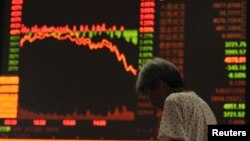 Seorang investor di Fuyang, Anhui, tampak lesu mengamati monitor indeks saham China yang kembali merosot.