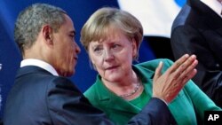 U.S. President Barack Obama and German Chancellor Angela Merkel talk at the G20 summit in Cannes, France, November 3, 2011