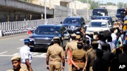 FILE - Policemen stand guard as the motorcade of Chinese President Xi Jinping arrives outside the airport in Chennai, India, Oct. 12, 2019. 