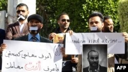 FILE - Libyan journalists hold a portrait of fellow reporter Mohammed bin Khalifa, who was killed the previous day while covering militia clashes, during a protest to denounce violence against journalists, in Tripoli, Jan. 20, 2019. 