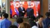 People watch a TV screen showing North Korean leader Kim Jong Un, right, welcoming Chinese President Xi Jinping, at the Seoul Railway Station in Seoul, South Korea, Friday, June 21, 2019. 